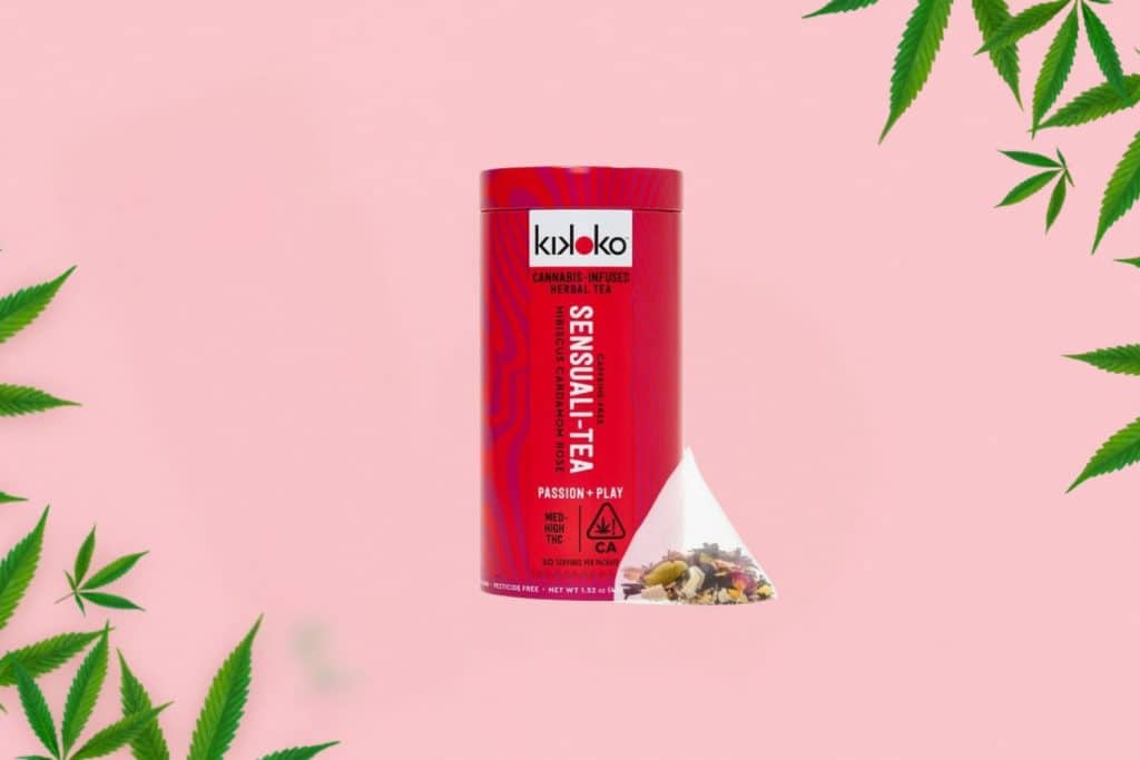 Kikoko Sensuali-Tea cannabis-infused herbal tea in a red container, with a tea bag filled with herbal ingredients, set against a soft pink background with cannabis leaves.