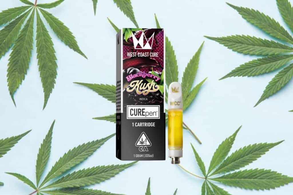 West Coast Cure Blackberry Kush vape cartridge next to its black and red packaging, set against a light blue background with cannabis leaves.