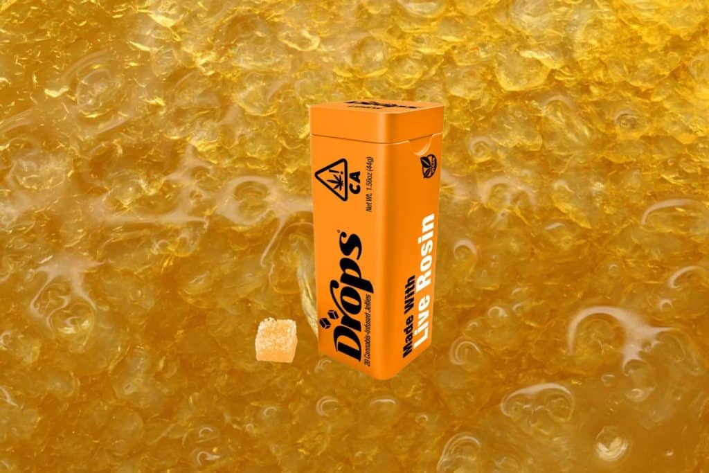 Orange (THC Bomb) Creative Live Rosin Jellies by Drops packaging against a golden live rosin texture background, highlighting the premium solventless cannabis extract used in the product.